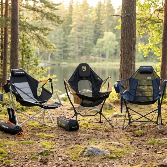 Five different freestanding hammock chairs, including models from NEMO, KingCamp, and ENO, set up side-by-side in a serene pine forest clearing near a calm lake.